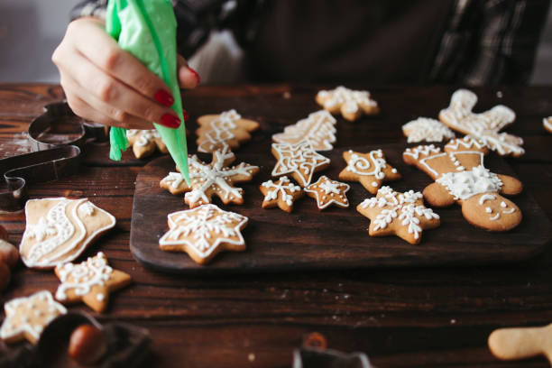 istock Woman decorating gingerbread cookies at kitchen 1271088339