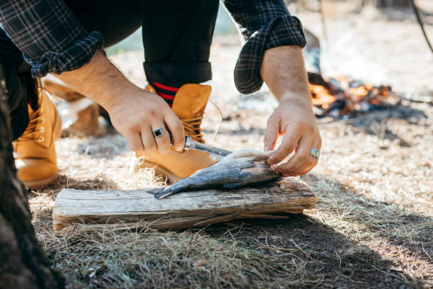istock A man with a knife cuts fish in forest 1271090783