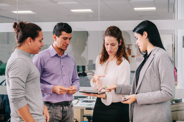 istock Group of office workers at a meeting around the boss 1271095515
