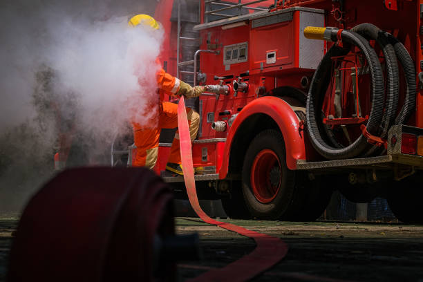Fire trucks in front of a large fire in a Pallet factory in an industrial area in the city of Kampen, The Netherlands. Fireman are trying to put out the fire.