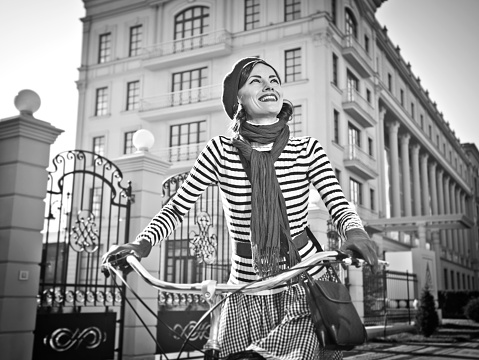 woman on the bike, retro, skirt, street. Girl on bike in city center. On the background office building