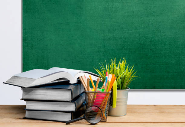istock Desk with book and stationery with a chalkboard background 1271108436