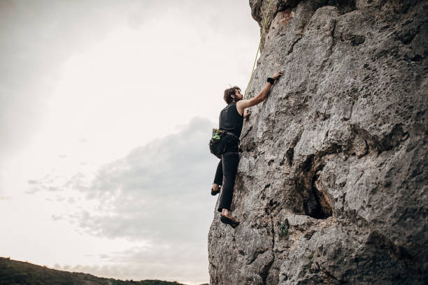 istock Young athletic male free climber climbing on the rock 1271108507