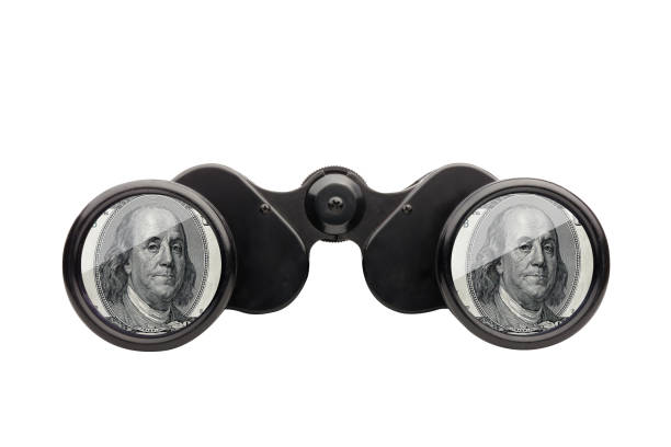 istock Studio shot looking through binoculars with dollar signs isolated 1271108605