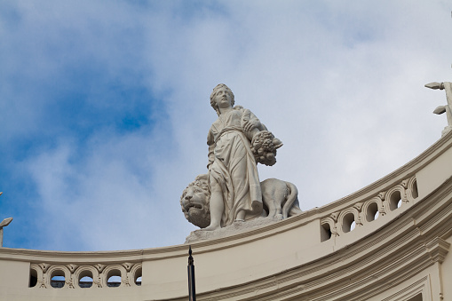 Statue of woman with lion on roof of belgian royal library in Brussels at Mons des Arts