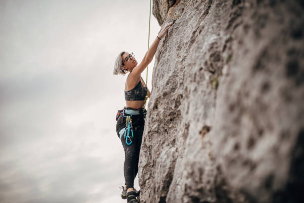 istock Young female free climber climbing on the rock 1271109444