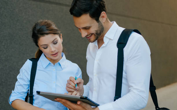 istock Two colleagues reading electronic document on digital tablet outdoors 1271109474