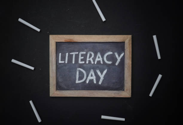 istock Literacy Day Written on Chalkboard with White Chalk Isolated on Black Background 1271109685