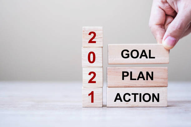 商人手握木立方體與文本2021目標,計劃和行動在表背景。解決方案、策略、解決方案、目標、業務和新年假期概念。 - 2021 圖片 個照片及圖片檔