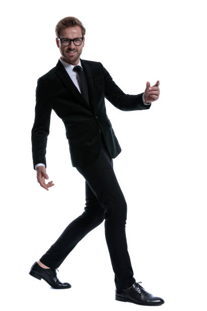 istock elegant cool man in black suit smiling and walking 1271113725