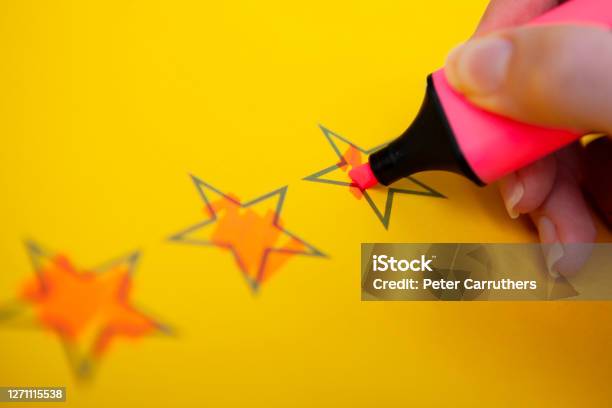 Hand Holding Highlighter And Colouring Rating Stars Stock Photo - Download Image Now