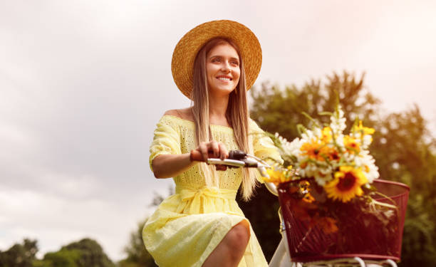 istock Happy female riding bicycle in park 1271115673
