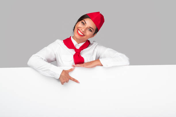 istock Cheerful flight attendant pointing at banner 1271115728
