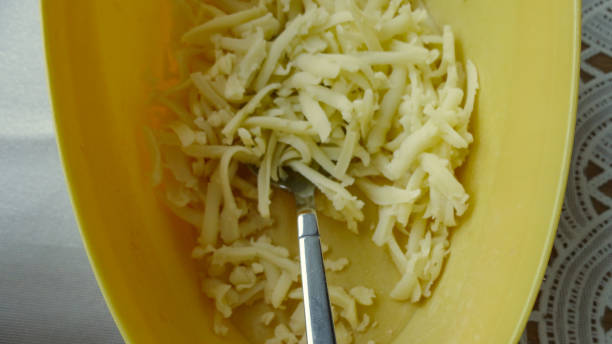 istock Pile of grated cheese isolated on yellow background 1271117864