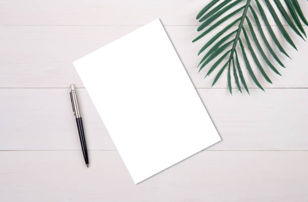 istock Blank paper sheet copy space with mockup and leaf on wooden table, poster and invitation, postcard decoration your design or branding, simplicity and minimal, nobody, flat lay, top view. 1271121407