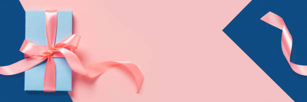 istock Holiday card. A blue box with a pink bow on two-toned background. 1271123143