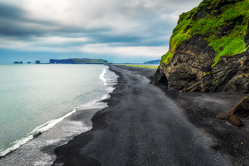 Aerial view of the Reynisfjara black sand beach with Dyrholaey peninsula in the background. This popular icelandic beach is located near Vik i Myrdal in south Iceland.