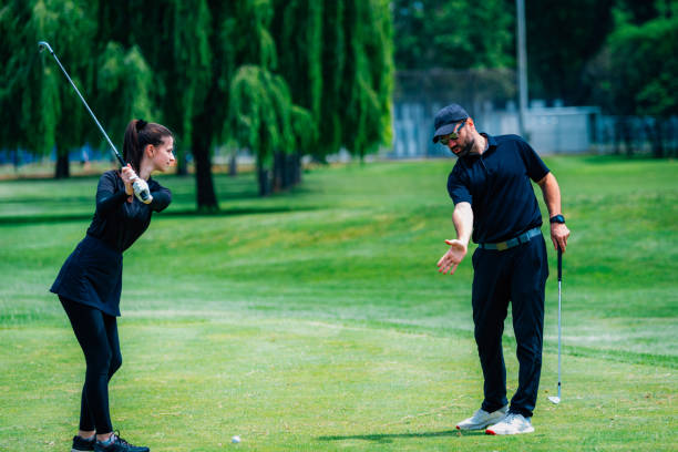istock Playing golf. Young woman playing golf with golf instructor 1271134622