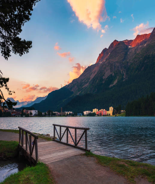 Sunset above St. Moritz with lake and Swiss Alps in Switzerland Sunset above St. Moritz with lake also called St. Moritzsee, a wooden footbridge in the foreground and Swiss Alps in the background in Engadin, Switzerland. maloja region stock pictures, royalty-free photos & images