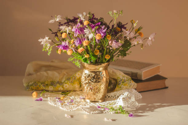 istock Still life with summer flowers and books 1271137130