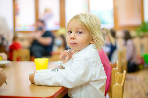 istock Toddler child, eating breakfast in kindergarten 1271138709