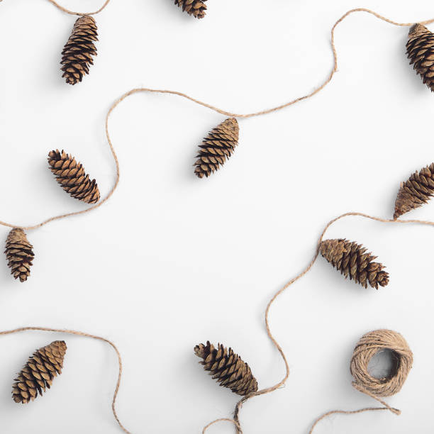 istock Zero waste christmas garland made from pine cone and natural jute twine. Square composition, flat lay, top view. Eco friendly minimal christmas mockup. White background 1271140511