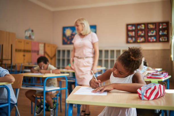 istock Focused elementary school children having an exam with a teacher 1271141555