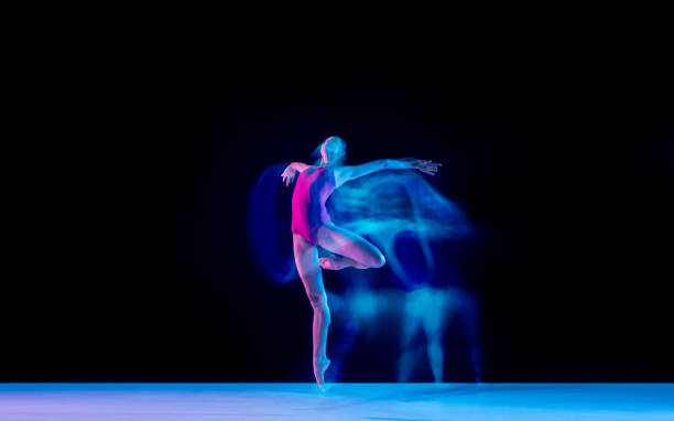 istock Young and graceful ballet dancer isolated on black studio background in neon mixed light 1271142087