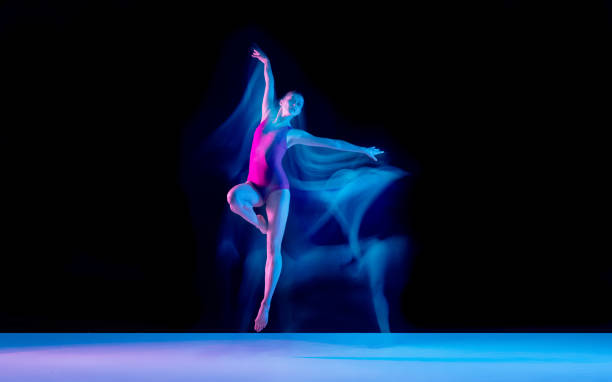 istock Young and graceful ballet dancer isolated on black studio background in neon mixed light 1271142099
