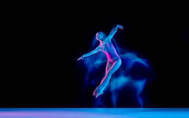 istock Young and graceful ballet dancer isolated on black studio background in neon mixed light 1271142106