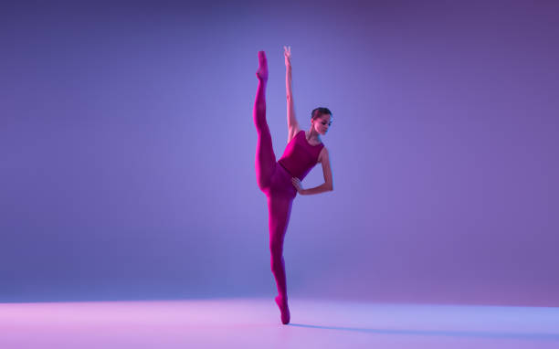 istock Young and graceful ballet dancer isolated on purple studio background in neon light 1271142111