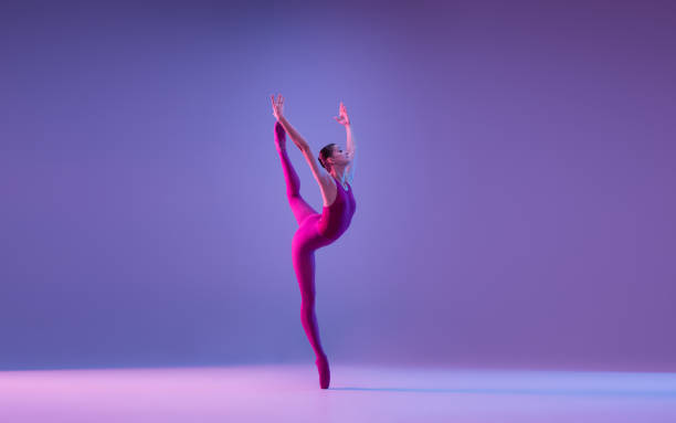 istock Young and graceful ballet dancer isolated on purple studio background in neon light 1271142116