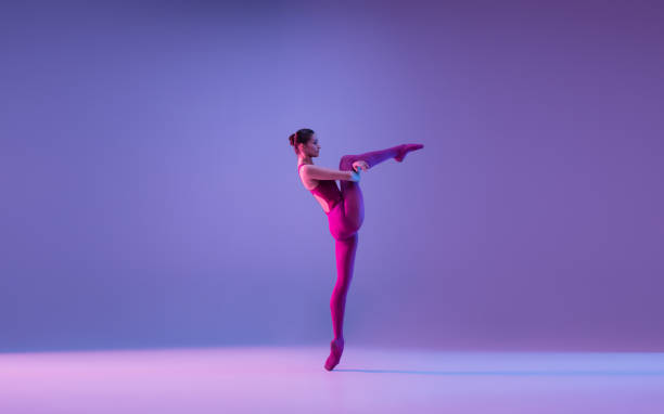 istock Young and graceful ballet dancer isolated on purple studio background in neon light 1271142123