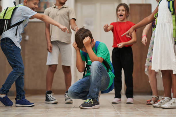 istock Elementary school children mocking and bullying a student in a hallway 1271142937