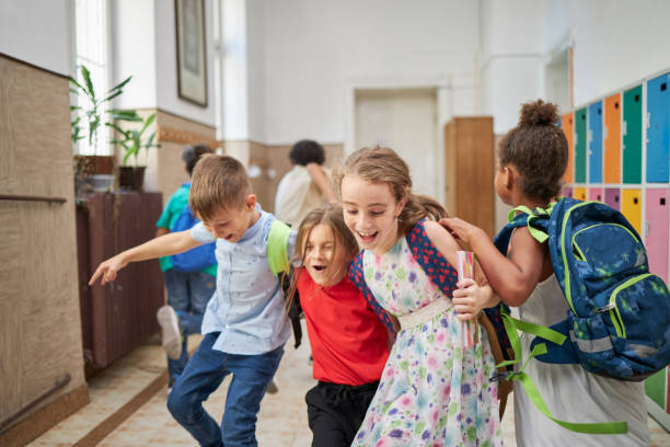 istock Playful ecstatic elementary school children running trough a hallway 1271143018