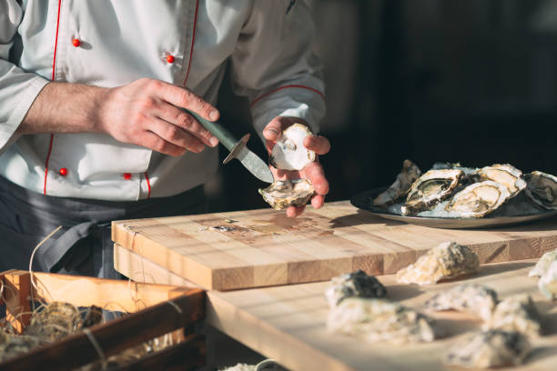 istock Opening the hollow and flat oysters. Chef opens oysters in the restaurant. 1271147874