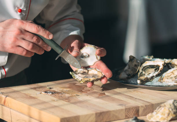 istock Opening the hollow and flat oysters. Chef opens oysters in the restaurant. 1271147887