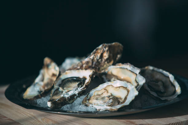 istock Oysters on a black plate on a wooden background. 1271147955
