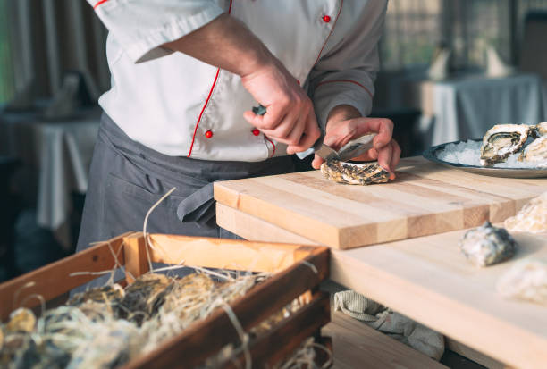istock Opening the hollow and flat oysters. Chef opens oysters in the restaurant. 1271148095