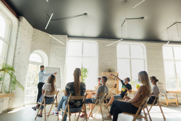 istock Male speaker giving presentation in hall at university workshop. Audience or conference hall 1271148520