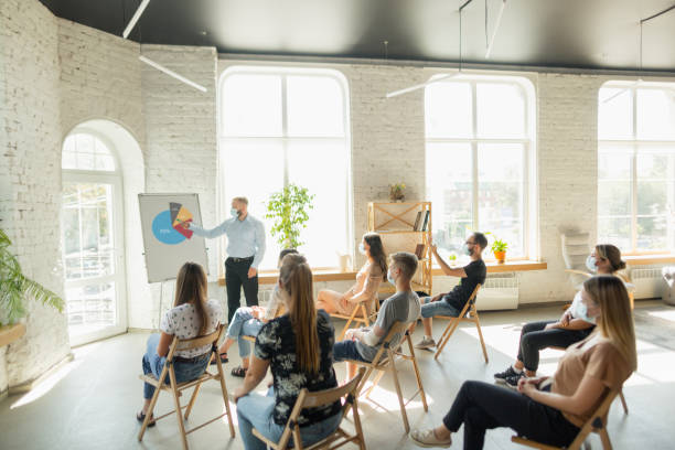 istock Male speaker giving presentation in hall at university workshop. Audience or conference hall 1271148528