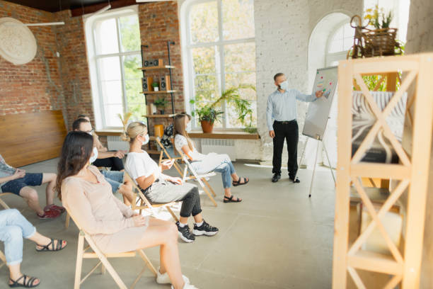 istock Male speaker giving presentation in hall at university workshop. Audience or conference hall 1271148549