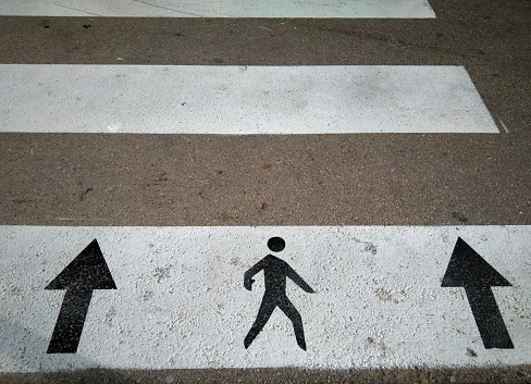Pedestrian crossing or zebra crossing detail with signs indicating the direction of passage