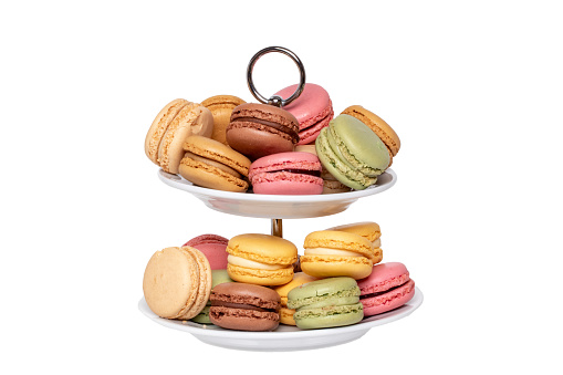 Macaron isolated. Close-up of colourful French macaroons on a two-storey etagere isolated on a white background. Pastries, desserts and sweets. Macro.