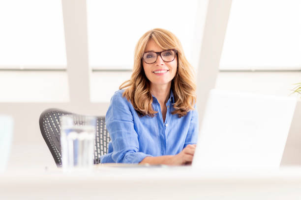 istock Attractive mature using laptop while sitting at desk at home 1271151567