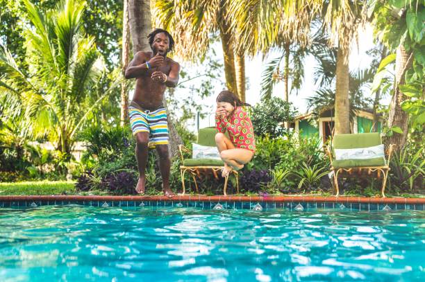 istock Man and child jump into backyard pool 1271151738