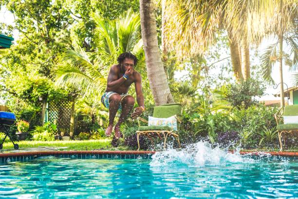 afroamerykanin rozpryskuje się w przydomowym basenie - cannonball zdjęcia i obrazy z banku zdjęć