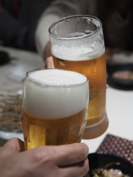 istock Two people toasting with beer glasses at the dinner table 1271153806