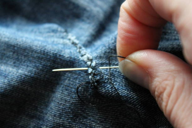 istock hand sewing with needle denim fabric closeup 1271154468