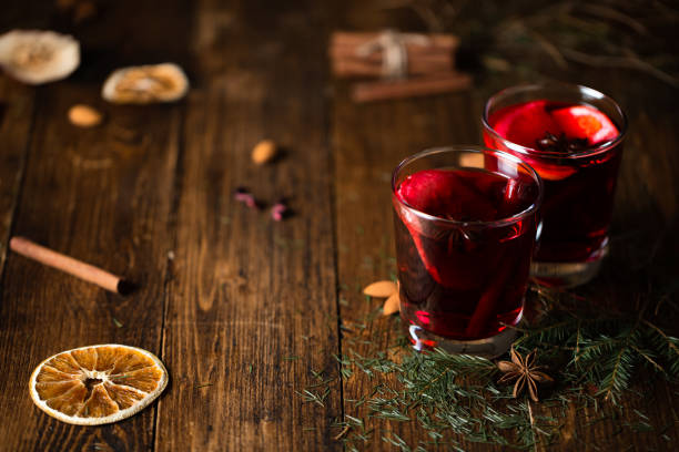 una mesa de madera con especias dispuestas en ella, agujas de abeto y anillos de naranja seco - mulled wine punch cocktail christmas fotografías e imágenes de stock